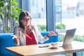 What do you need? Portrait of confused beautiful stylish brunette young woman in glasses sitting and looking at camera and asking Royalty Free Stock Photo