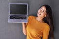 What do you think of this. Portrait of an attractive young woman holding up a laptop with a blank screen. Royalty Free Stock Photo