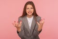 What do you want from me? Portrait of young mad woman in business suit raising hands and looking with anger hate Royalty Free Stock Photo