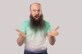 What do you want? Portrait of angry middle aged bald man with long beard in light green t-shirt standing, looking at camera, Royalty Free Stock Photo