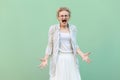 What do you want? Portrait of angry young blonde woman in white shirt, skirt, and striped blouse with eyeglasses standing and Royalty Free Stock Photo