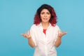 What do you want? Portrait of annoyed hipster woman with fancy red hair standing with raised hands