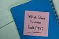 What Does Success Look Like? write on sticky notes isolated on Wooden Table