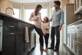 This is what domestic bliss looks like. two happy parents bonding with their little girl in the kitchen at home.