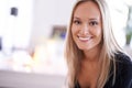 What a fetching smile. Portrait of a young blonde woman relaxing at home. Royalty Free Stock Photo