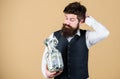 What is a good way of investing money. Bearded man thinking of investing money into business. Businessman calculating