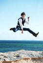 What a great feeling. Happy young man jumping in the air with the ocean in the background. Royalty Free Stock Photo