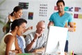 What a great financial year. A group of young colleagues celebrating something around a computer in their office. Royalty Free Stock Photo