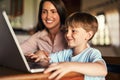 What happens if I press this. an adorable little boy using a laptop with his mother at home. Royalty Free Stock Photo