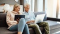 This is what happens when you save for retirement. a mature couple using a digital tablet and laptop on the sofa at home Royalty Free Stock Photo