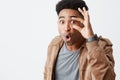 What the heck is going on. Close up of young dark-skinned man with afro haircut in casual stylish clothes being shocked