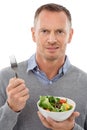 What am I supposed to do with this. Studio portrait of a frowning man holding a bowl of fruit salad isolated on white. Royalty Free Stock Photo