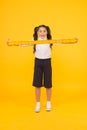 What a long ruler. Surprised little student holding rigid wooden ruler on yellow background. Small child taking Royalty Free Stock Photo