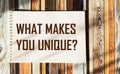 What makes you unique The phrase is written on a notepad and striped background. Royalty Free Stock Photo
