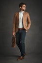 What movers and shakers are wearing. Studio shot of a handsome young man posing against a gray background.