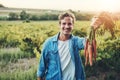 This is what my hard work has created. Cropped portrait of a handsome young man holding a bunch of carrots and smiling Royalty Free Stock Photo