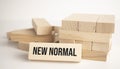 The what NEW NORMAL is written on one of the many scattered wooden blocks