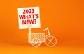 2023 what is new symbol. Wooden clothespin, white sheet of paper with words 2023 what is new. Miniature bicycle model. Beautiful Royalty Free Stock Photo