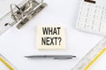WHAT NEXT - business concept, message on the sticker on folder background with calculator Royalty Free Stock Photo