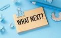 What Next text on white sticky note on blue background Royalty Free Stock Photo