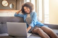 What a nice day to work from home. a cheerful young woman working on a laptop while being seated on a couch at home Royalty Free Stock Photo