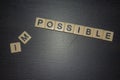 What is possible? Not impossible. Letter tiles lined up on black background with letters removed. Royalty Free Stock Photo