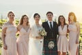 What a proud moment in our lives. Portrait of a cheerful bride and groom standing together with the brides maids arm in