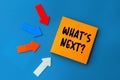 What`s Next - concept of text on sticky note. Orange square sticky note and colorful arrows on blue background Royalty Free Stock Photo