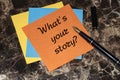 What`s your story, a question mark, a note on an orange sticker lying on a marble table Royalty Free Stock Photo