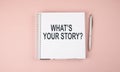 WHAT`S YOUR STORY text on notebook with pen on the pink background Royalty Free Stock Photo