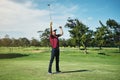 What a shot. a cheerful young male golfer lifting up his hands in success of playing a good shot outside during the day. Royalty Free Stock Photo