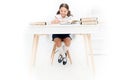 What should be height of study table. Schoolgirl doing homework at table. Adorable pupil little girl studying at table