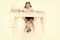 What should be height of study table. Schoolgirl doing homework at table. Adorable pupil little girl studying at table