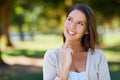 What should I do on this beautiful day. a beautiful young woman contemplating something while at the park. Royalty Free Stock Photo