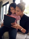 What should we watch next. a mother and daughter using a digital tablet together at home. Royalty Free Stock Photo