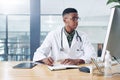 What are the side effects again. a handsome young doctor sitting alone in his office at the clinic and writing in his Royalty Free Stock Photo