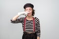 Young unhappy mime girl squeezing nose with fingers with disgust expression.