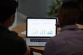 What story do the stats tell. two young businessmen using a laptop with graphs on the screen during a meeting in a Royalty Free Stock Photo