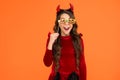 What a surprise. kid wear devil horns. child with funny party attribute. teen girl has curly hair and wear dress for