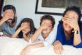 What surprise will the weekend hold for us. a family covering their eyes while lying down on a bed at home. Royalty Free Stock Photo