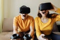 What to do at home. A guy and a girl play virtual games. People are wearing virtual reality helmets for game.