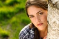 What a tree hugger. Shot of a beautiful young woman leaning against a tree in a forest. Royalty Free Stock Photo