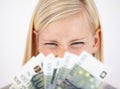 What a windfall. An excited young woman looking at her cash with scrunched eyelids. Royalty Free Stock Photo