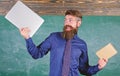 What would you prefer. Teacher bearded hipster holds book and laptop. Teacher choosing modern teaching approach. Paper