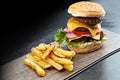 What would you sacri-fries for this meal. a delicious triple decker hamburger with fries.