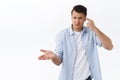 What wrong with you. Portrait of frustrated and annoyed man hold finger against head and look perplexed, raise hand in