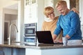 What you doing. a mature couple using their laptop in the kitchen. Royalty Free Stock Photo