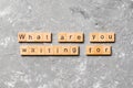 What are you waiting for word written on wood block. What are you waiting for text on cement table for your desing, Top view Royalty Free Stock Photo