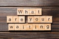 What are you waiting word written on wood block. What are you waiting text on wooden table for your desing, Top view concept Royalty Free Stock Photo