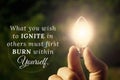 What you wish to ignite in others must first burn within yourself quote with hand holding shining bulb background